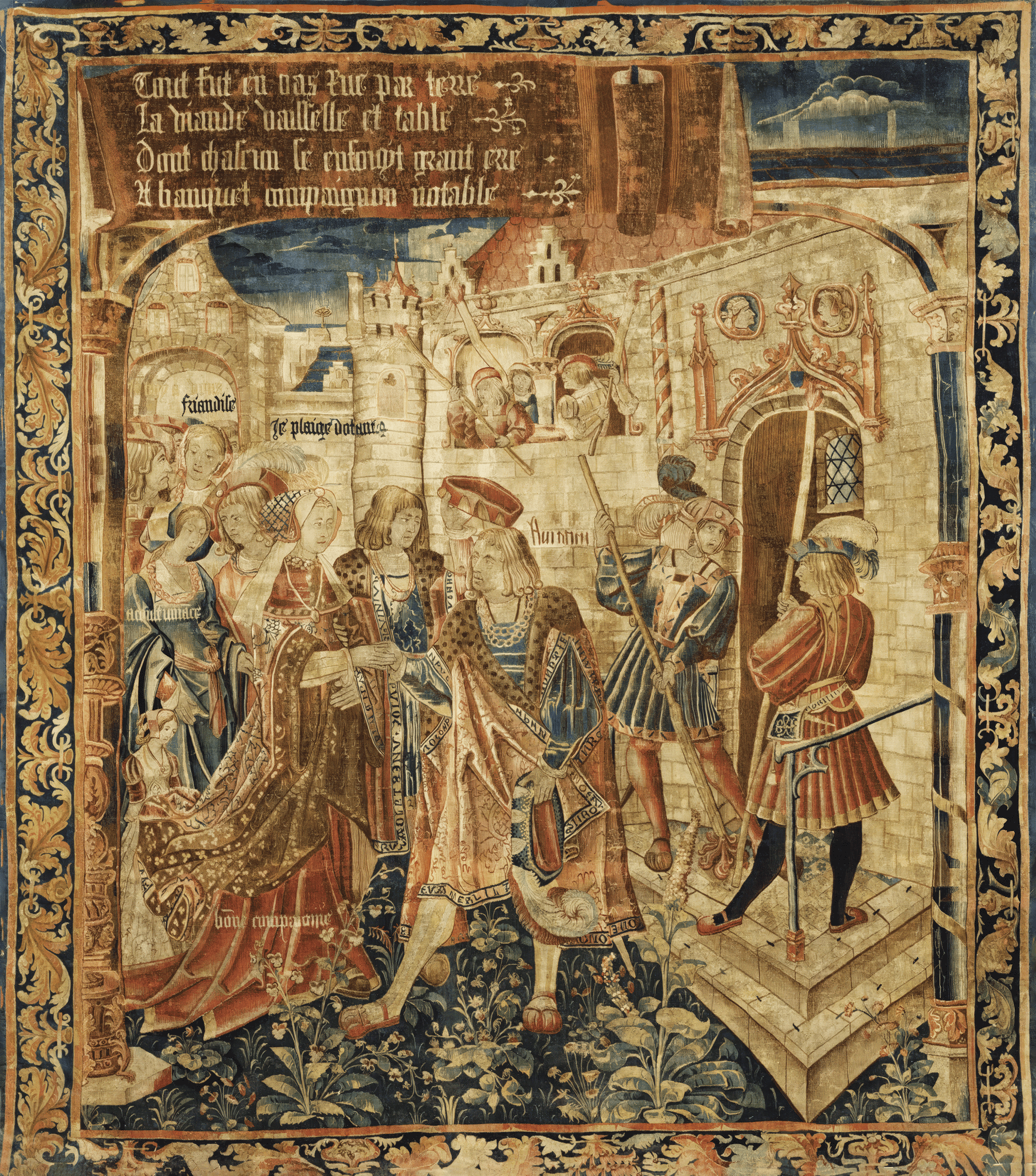 Medieval-style tapestry reproduction depicting a vibrant Gothic scene with elaborately dressed noble figures, medieval architecture, and intricate floral borders. The tapestry includes text in Old French, showcasing storytelling elements amidst rich details and vibrant colors