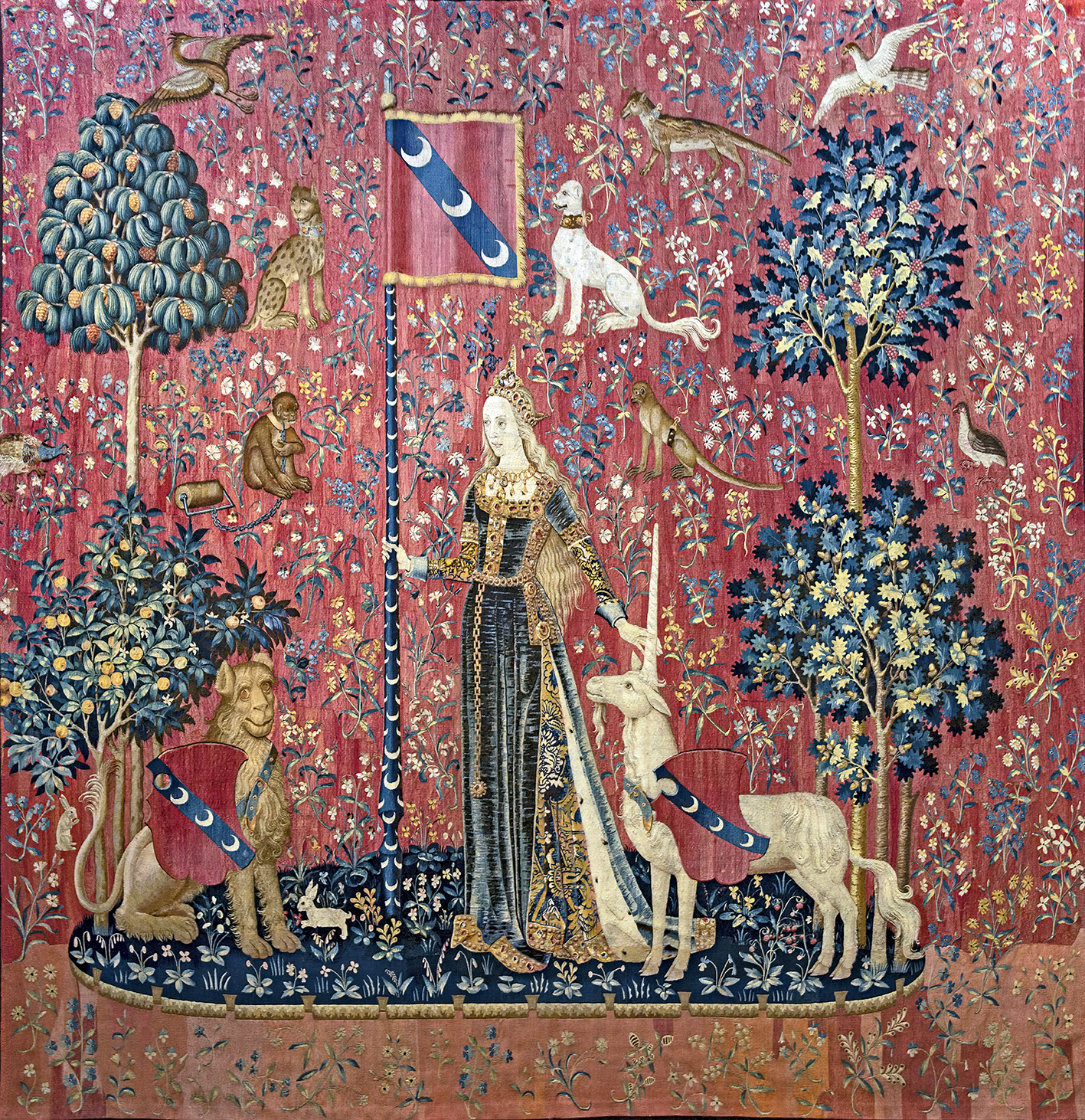 At the center, there is a noblewoman standing, perhaps representing the sense of touch, which is a common theme in this series. She is dressed in an elaborate gown adorned with intricate patterns and floral motifs, indicating a high status. The dress is form-fitting at the top and flares out at the bottom, typical of medieval fashion, and she wears a headdress that also signifies nobility.
